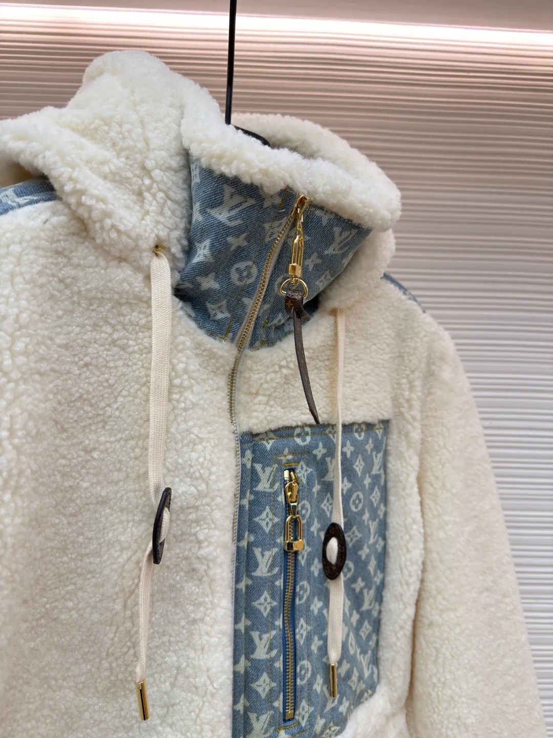 LOUIS VUITTON Letter jacquard splicing lamb wool ski hooded jacket ●Original version: purchased and developed by 26909 ●Item number: 1682241-C35 ●Fabric: lamb wool fabric ●Technology: jacquard production ●Color: off-white ●Version: fitted version ●Weight: about 1245 grams ●Size: 34-36-38-40-42-44 ●Description: The main body of this lamb wool spliced denim jacket is made of imported imitation lamb wool fabric, which has been processed by carding and shaping processes. The wool feels fluffy and soft and is not easy to shed and pill. The fabric has a uniform weight and has both warmth retention and breathability. The neckline, placket and chest pockets are spliced ​​with classic presbyopic denim. The denim is enzymatically washed to create a natural aged texture. The presbyopic pattern is embossed, making the texture three-dimensional and not easy to fall off. The body adopts a loose hooded fit, with a built-in shaping lining on the brim and an adjustable drawstring design; a custom metal zipper is used at the placket, and the chain teeth are gold-plated for smooth pulling and anti-oxidation. The edges of the pockets are reinforced with double stitching, and the splicing of lambswool and denim is made by hand caulking. The stitching is fine and smooth. Every detail is strictly controlled, showing the craftsmanship and quality of high-end clothing. The overall wiring is straight and delicate, the fabric is comfortable and soft, and the color is consistent without color difference. It can be matched with the same style to create a fashionable look and control various occasions. Customized accessories, complete with three standards, same style for men and women!